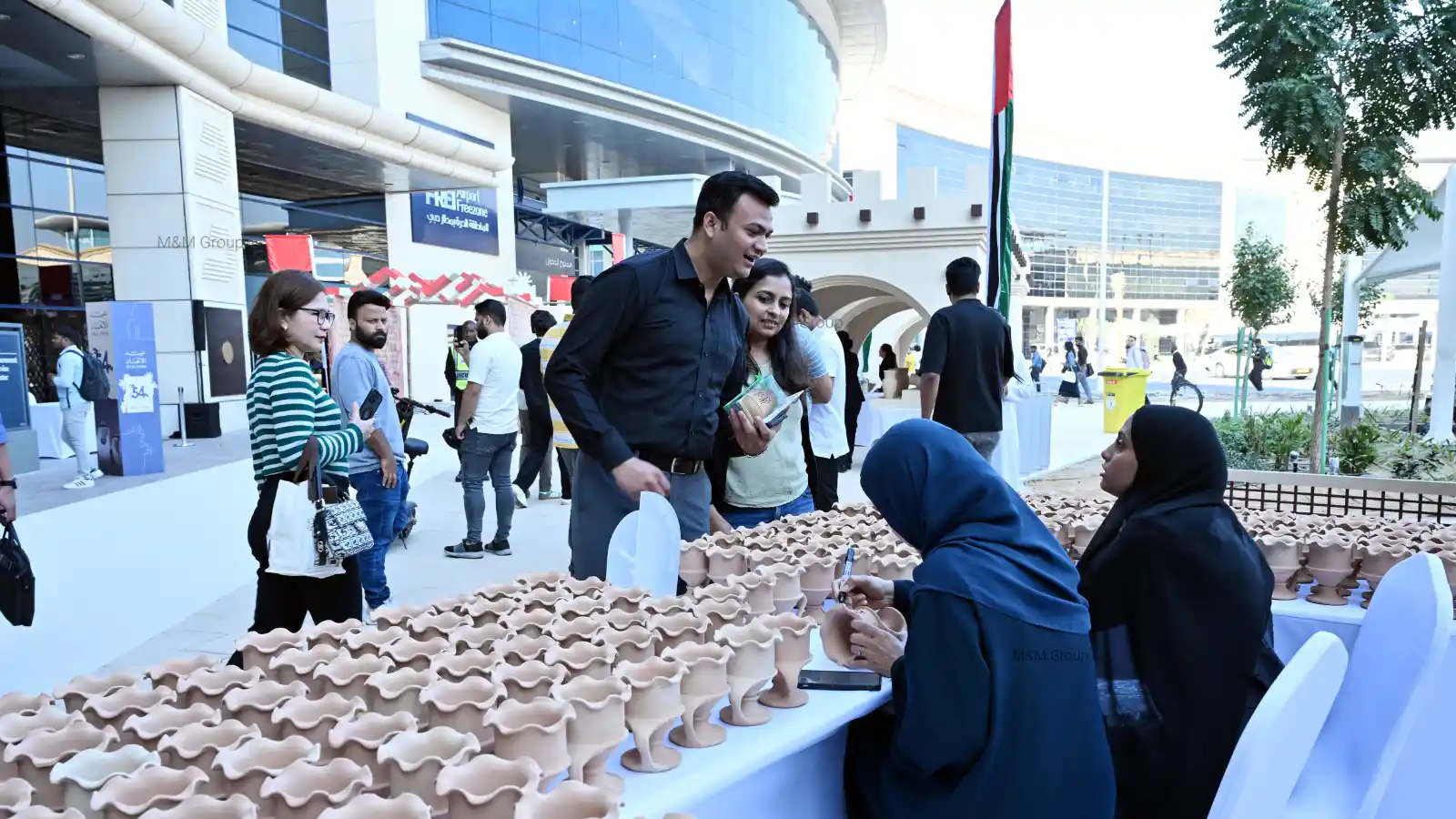 Guests participating in a traditional pottery workshop during the Dubai Airport Freezone UAE National Day celebration in Dubai