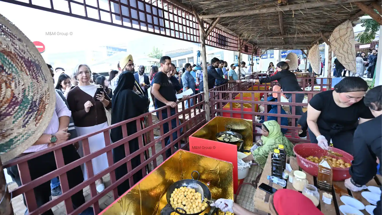 Guests visiting live luqaimat, regag and chebab cooking stations during the Dubai Airport Freezone UAE National Day celebration in Dubai