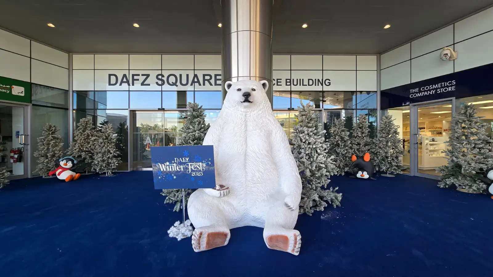 DAFZ Winter Festival entrance décor with polar bear display, penguins, and snow-covered trees in Dubai